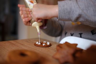 Close-up of child decorating cookie