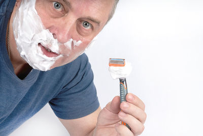 Close-up of man holding hands over white background