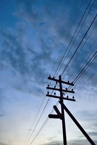 Low angle view of electricity pylon against sky