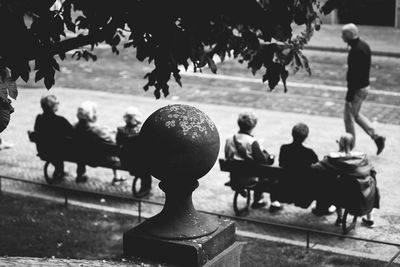 High angle view of friends sitting on benches in city