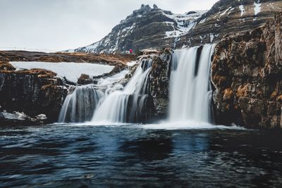 Scenic view of waterfall against sky