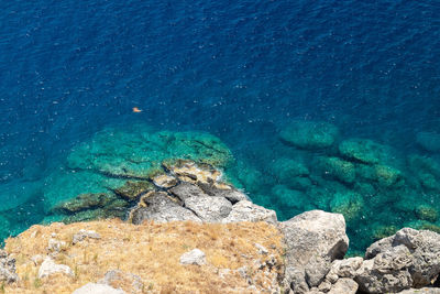 View from the acropolis on the rocky coast with blue and turquoise water in lindos on rhodes island