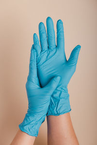 Close-up of woman hand against blue wall