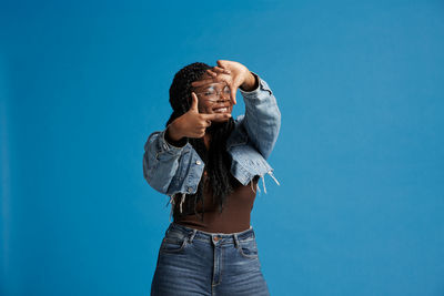 Woman standing against blue wall