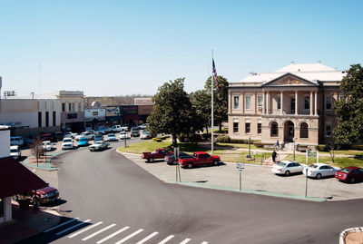 Cars on road in city against clear sky