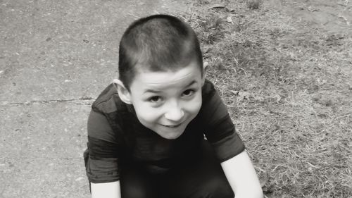 High angle portrait of boy smiling on field