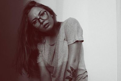 Portrait of young woman against wall