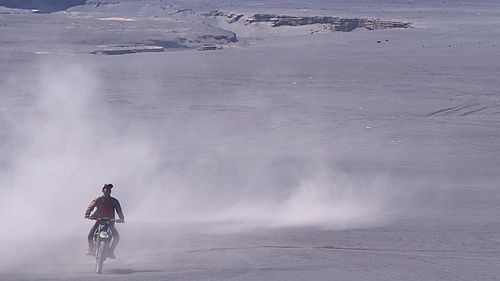 Full length rear view of a man bicycling on landscape