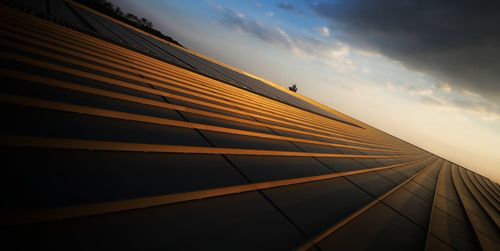 Low angle view of modern building against sky during sunset