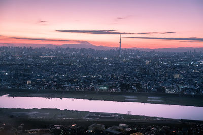 Scenic view of river and buildings against sky during sunset