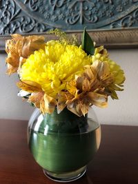 Close-up of yellow flower vase on table