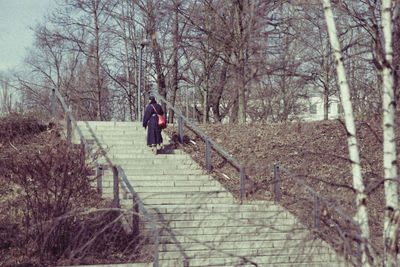 Woman standing on tree trunk