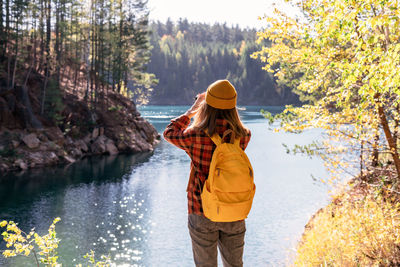 Rear view of woman standing by lake