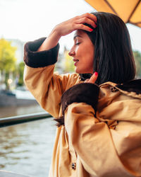 Young woman looking away while standing outdoors