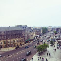 Panoramic view of people in city against clear sky