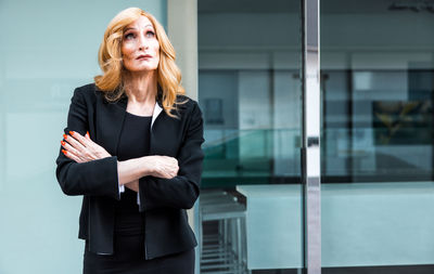 Portrait of young woman standing in office