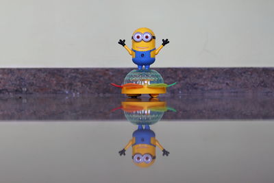 Close-up of toys on table against wall