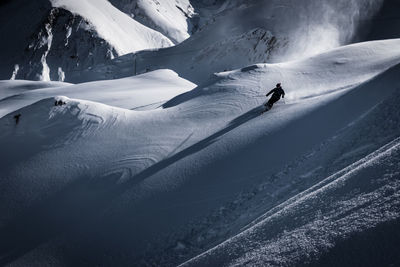 View of people skiing on snowcapped mountain