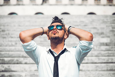 Portrait of young man wearing sunglasses standing outdoors