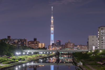 Illuminated buildings in city against sky