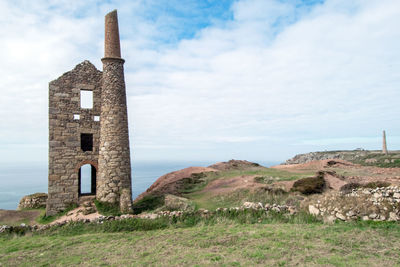 Old ruin building on field against sky