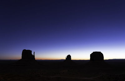 Silhouette rocks against clear sky at night