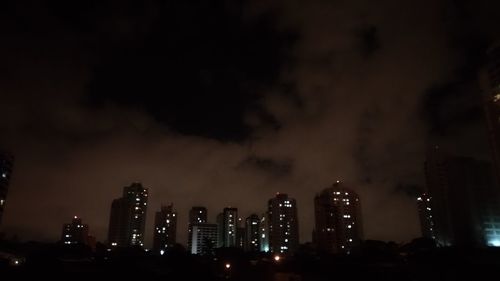 Low angle view of illuminated buildings against sky at night