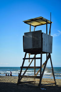 Lifeguard hut on beach against sky