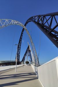 Low angle view of bridge against clear blue sky