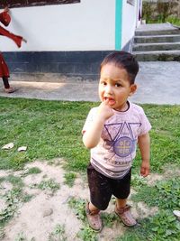 Cute boy standing on grass