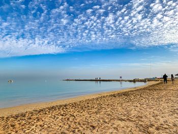 People on beach against sky