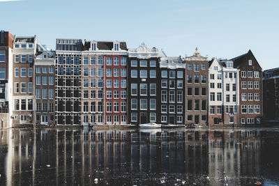 Reflection of buildings in canal against sky