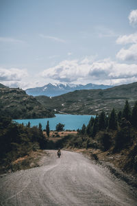 Scenic view of road by mountains against sky