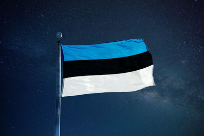 Low angle view of flag against blue sky