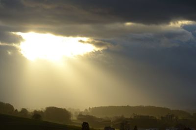 Sunlight streaming through clouds during sunset