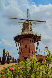 Traditional windmill on landscape against sky