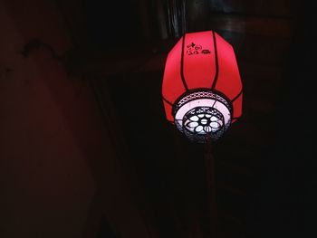 Low angle view of illuminated lamp hanging on ceiling