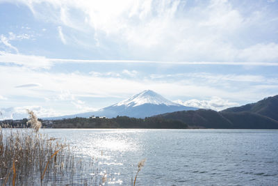 Scenic view of lake and snowcapped mountains against sky