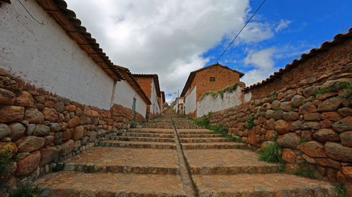Low angle view of steps amidst buildings against sky