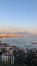 High angle view of townscape by sea against clear sky