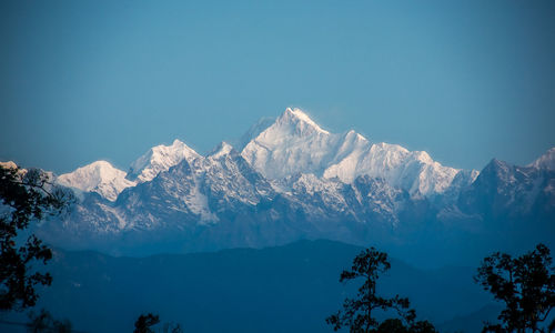 Scenic view of snowcapped mountains against clear blue sky