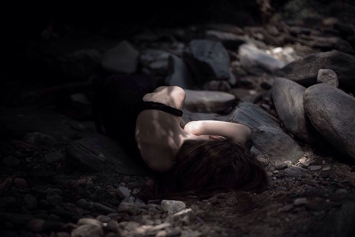 WOMAN LYING DOWN ON SHORE