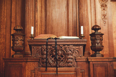 Open book on wooden podium against wall