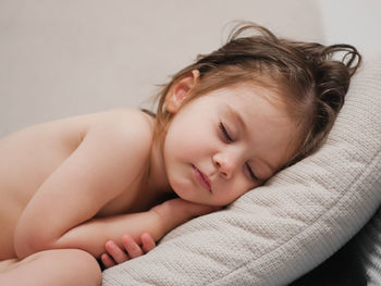 Portrait of young woman lying on bed at home