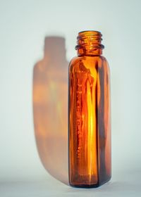 Close-up of glass jar on table against wall