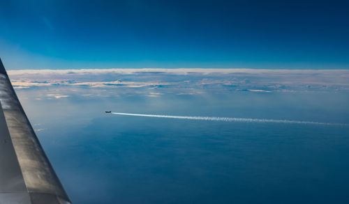 Aerial view of sea and vapor trails in sky