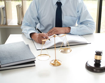 Mid section of a man sitting on table