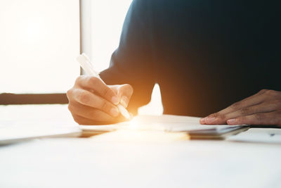 Close-up of woman hand holding paper on table