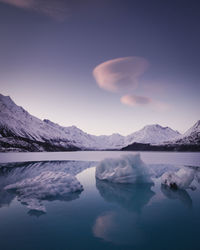 Scenic view of lake and mountains against sky during winter