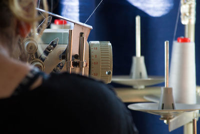 Rear view of woman using sewing machine